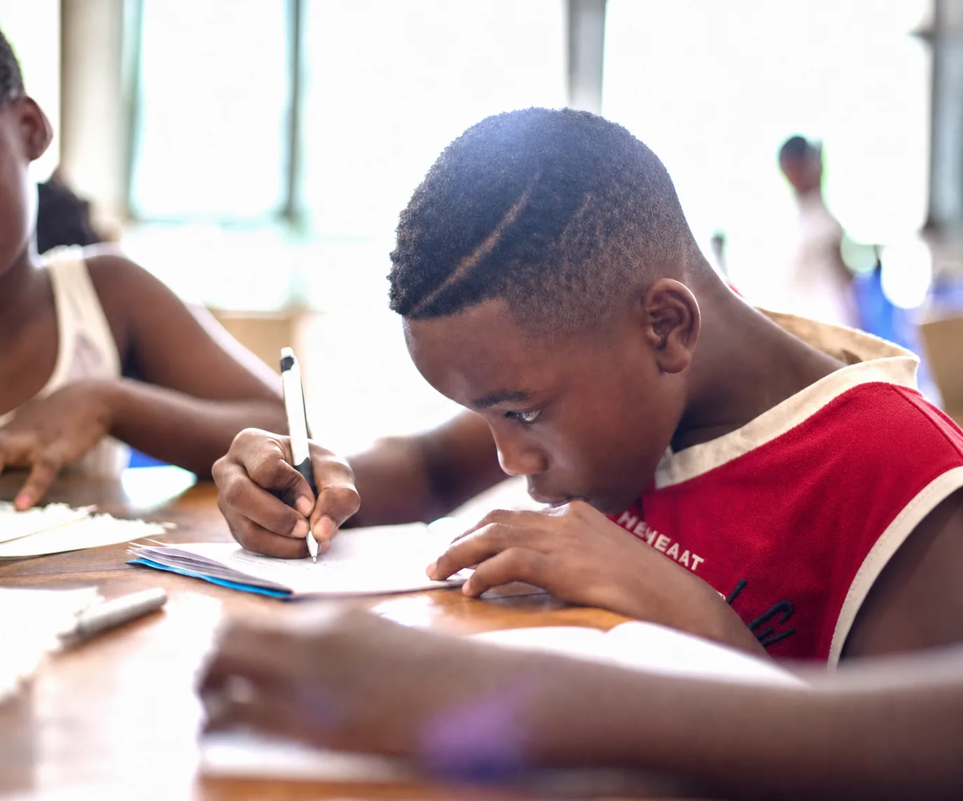 Jongere werkt geconcentreerd aan een schoolopdracht